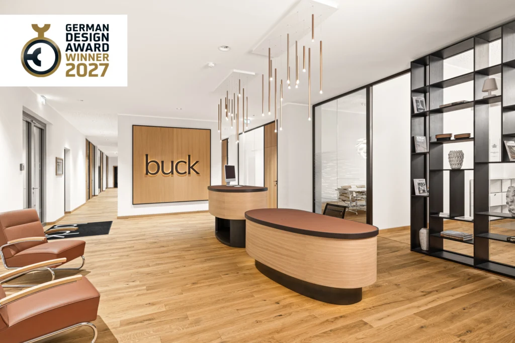 Foyer von buck Vermessung mit zwei Empfangstresen, Markenwand, Pendelleuchten und Lounge-Sesseln